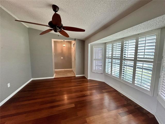Another view of the living room as you look back to the front entry and hall. Plantation shutters installed on the windows