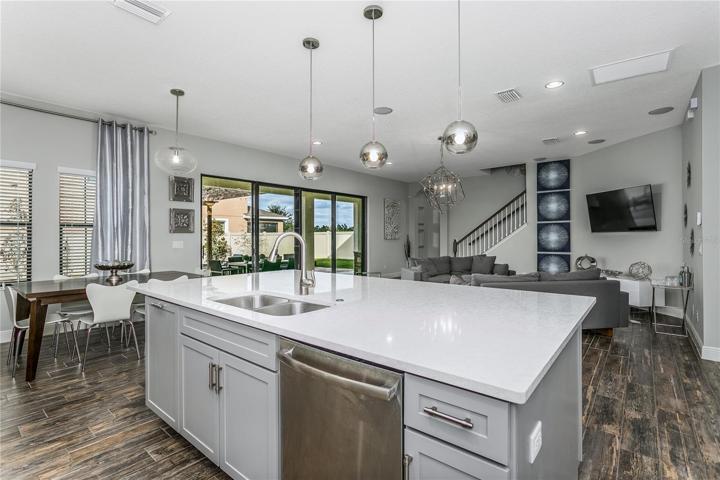KITCHEN open to living room with a view of the lovely pool area and backyard.