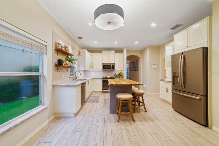 The true heart of this home is the gorgeous kitchen, another fresh and modern, yet neutral space - it boasts granite countertops, newer STAINLESS STEEL APPLIANCES, subway tile backsplash and an impressive oversized BUTCHER BLOCK ISLAND with cleverly designed hidden drawers for all your kitchen essentials!