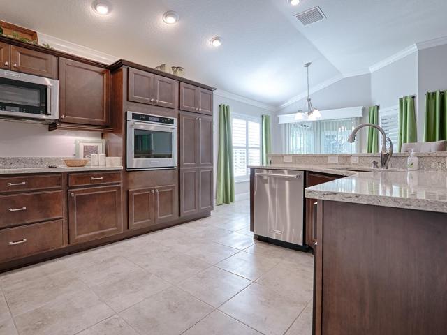 SPACIOUS KITCHEN WITH QUARTZ COUNTER TOPS, STAINLESS APPLIANCES WITH WALL OVEN AND SMOOTH TOP ELECTRIC COOKTOP.  DOUBLE DOOR PANTRY TOO!