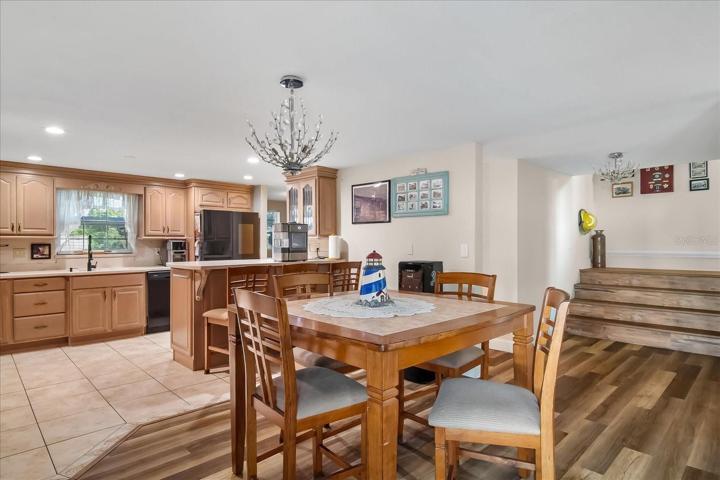 As you step onto the 1st level, you enter the dining area, kitchen and game room.  Notice the lovely wood laminate flooring.  Handsome tile is in all of the wet areas.