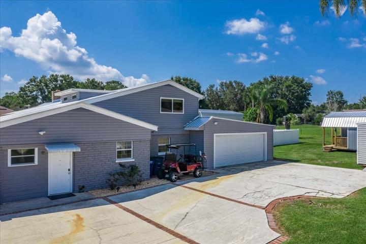 Large parking pad connects to the garage, the laundry room and the first shed.