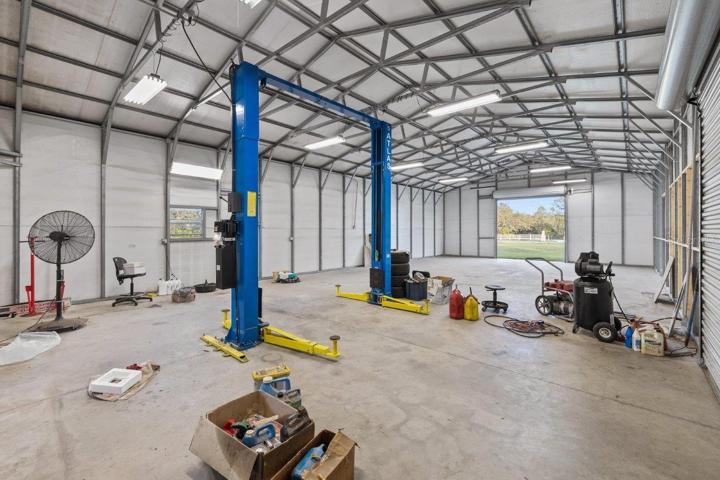 Inside of the 60'x30' Warehouse featuring a on demand hot water heater, electricity, Rotary 10,000Ib car lift, and two 10' garage doors.