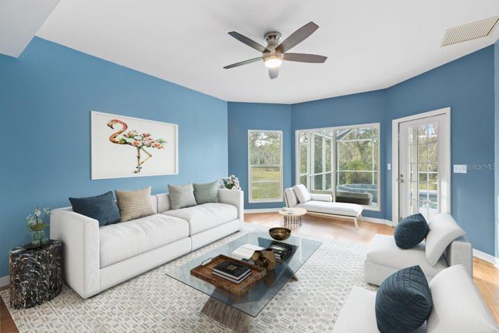 Spacious Family Room featuring Wood flooring, extended bay windows, and direct access to the screened-in lanai