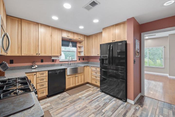 Gourmet Kitchen featuring wood cabinets, polished quartz counter tops, a stainless steal farmhouse sink, and a 36