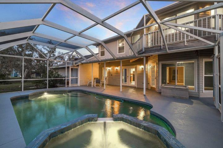 Spacious Screened-in lanai featuring a heated saltwater pool and spa, and out door shower.