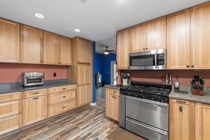 Gourmet Kitchen featuring wood cabinets, polished quartz counter tops, a stainless steal farmhouse sink, and a 36