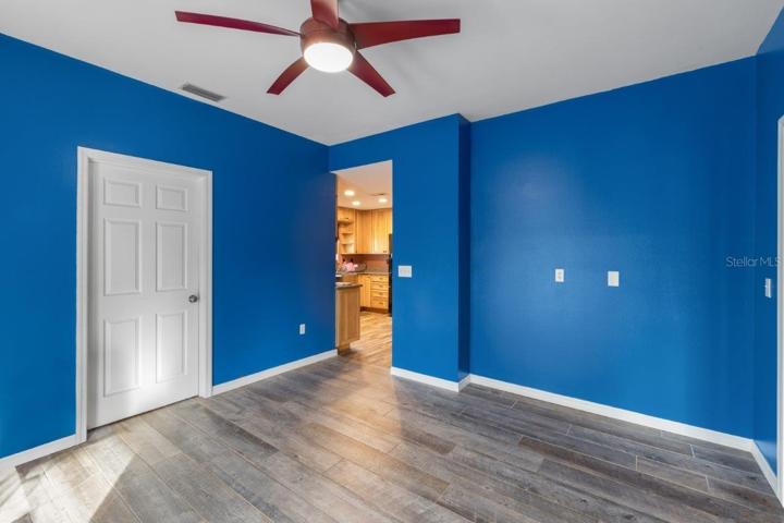 Office/ Den located off the kitchen and family room features porcelain wood-look tile, and French doors out to the screened-in lanai and pool!