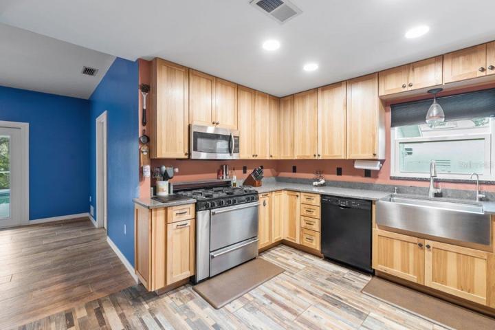 Gourmet Kitchen featuring wood cabinets, polished quartz counter tops, a stainless steal farmhouse sink, and a 36