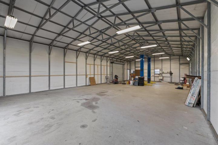 Inside of the 60'x30' Warehouse featuring a on demand hot water heater, electricity, Rotary 10,000Ib car lift, and two 10' garage doors.