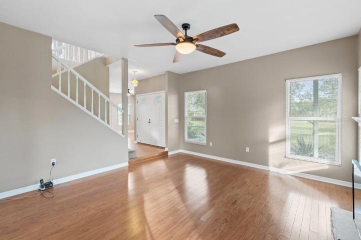 Living room featuring a wood burning fire place, wood floors, and 10' ceilings.