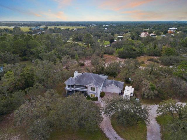 Aerial of the home featuring the circular driveway, wrap around porch, and attached two car garage.