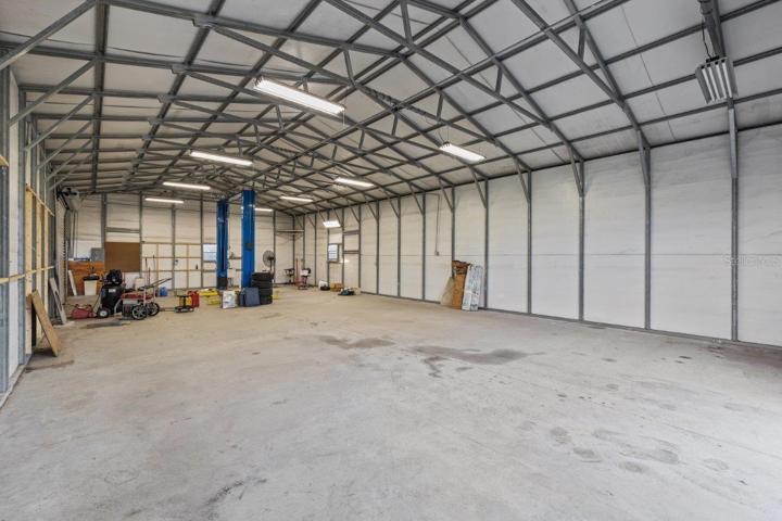 Inside of the 60'x30' Warehouse featuring a on demand hot water heater, electricity, Rotary 10,000Ib car lift, and two 10' garage doors.