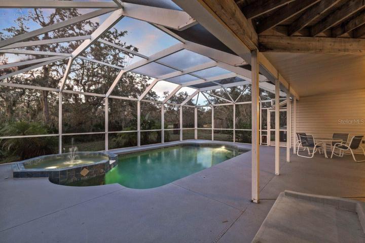 Spacious Screened-in lanai featuring a heated saltwater pool and spa, and out door shower.