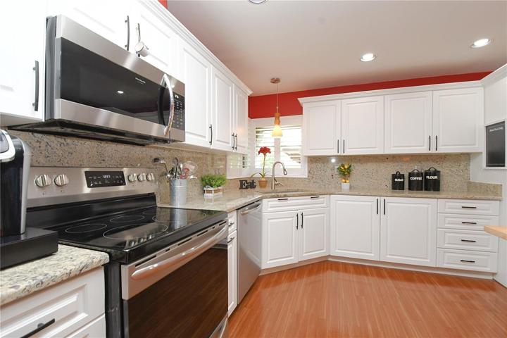 Recessed lighting and a glass pendant light above the kitchen sink.
