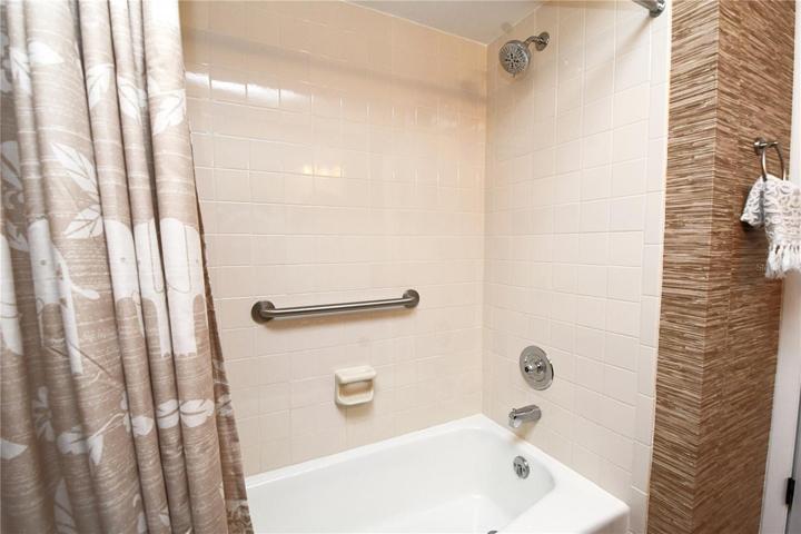 The guest bathroom features a tiled bathtub with shower.
