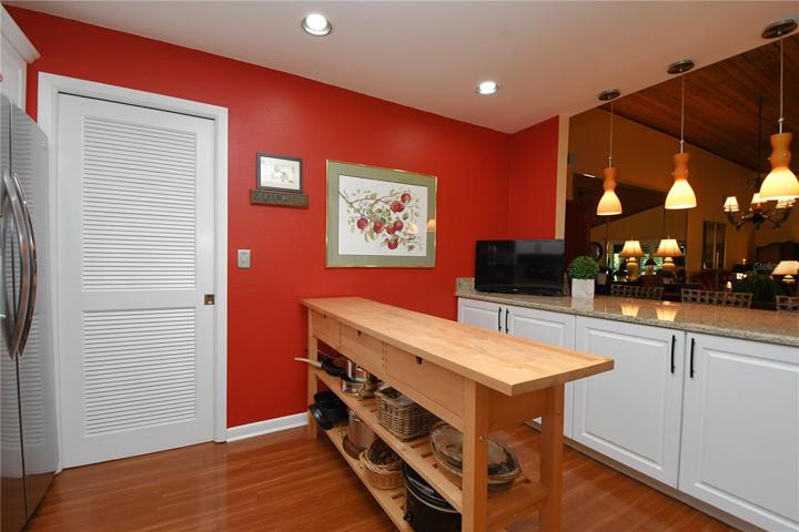 Artistic glass pendant lights above the breakfast bar make it both functional and attractive.