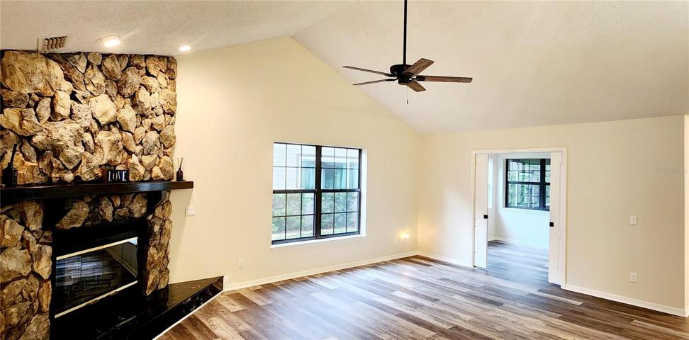 Living room with vault ceilings, wood burning fireplace and 3rd bedroom