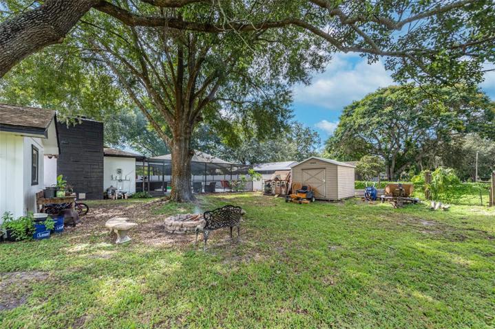 Backyard with a fire pit and shed.