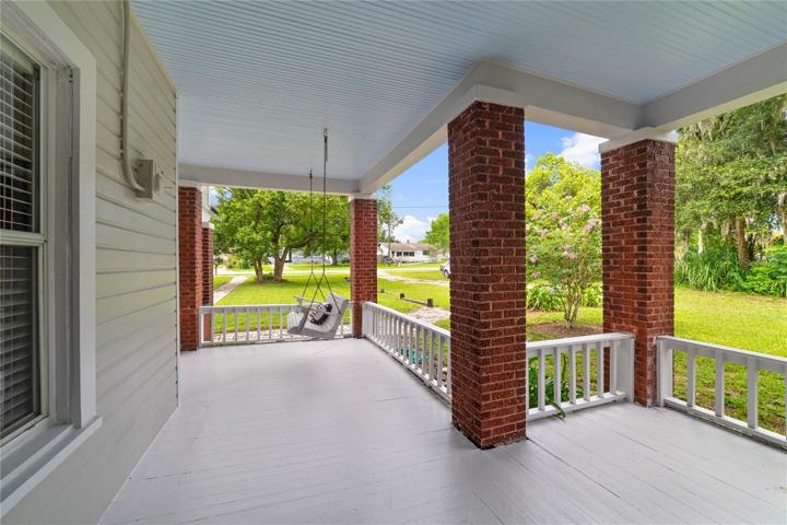 The exterior of this home showcases its timeless charm with a PARTIAL WRAP-AROUND PORCH that beckons you to sit back and relax as you enjoy the beauty of the surrounding landscape!