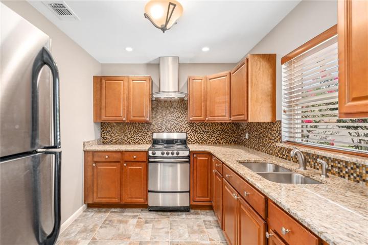 Renovated Kitchen with granite counter tops, recessed lighting and travertine tile.