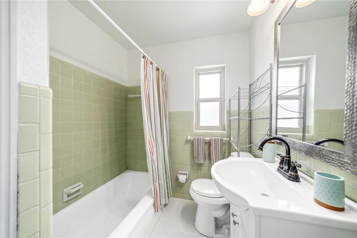 Hall bath with new penny tile flooring, vanity and refinished tub.
