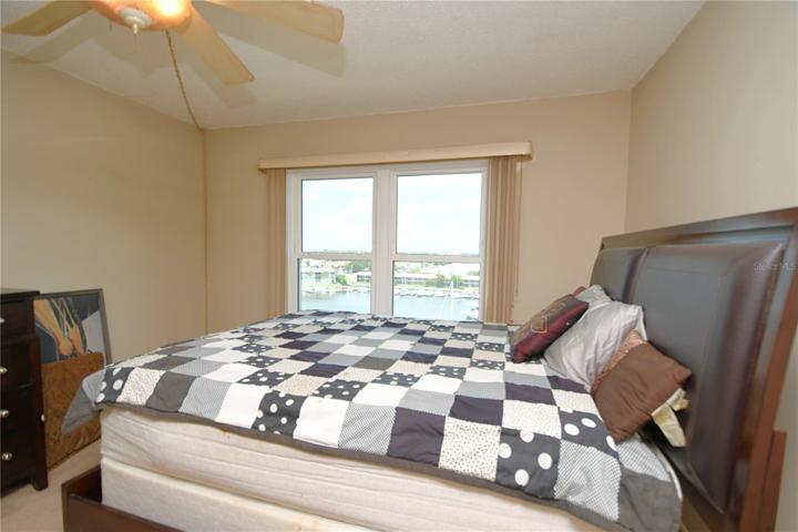The master bedroom offers a true sanctuary with a hurricane window, a ceiling fan, and two spacious closets.