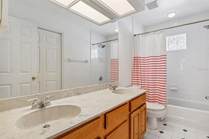 Guest bedrooms share full bath with linen closet, double sinks and tub/shower combo.