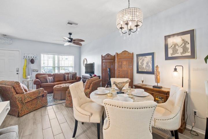 Dining Room Featuring a custom chandelier, and wood look tile flooring.