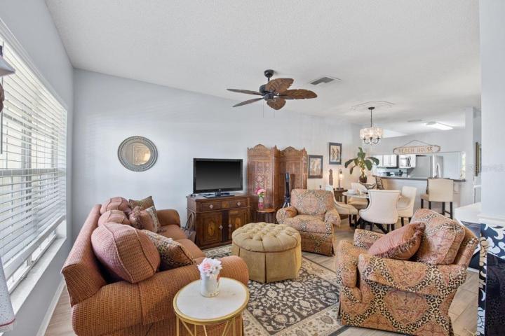 Spacious Living room featuring high ceilings, and wood look tile flooring.