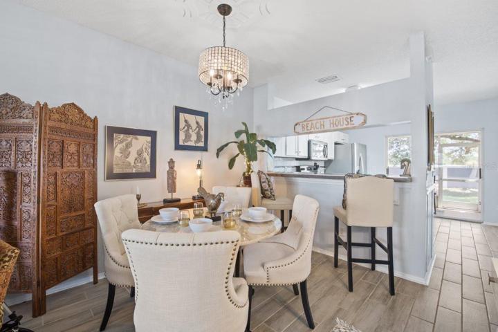 Dining Room Featuring a custom chandelier, and wood look tile flooring.