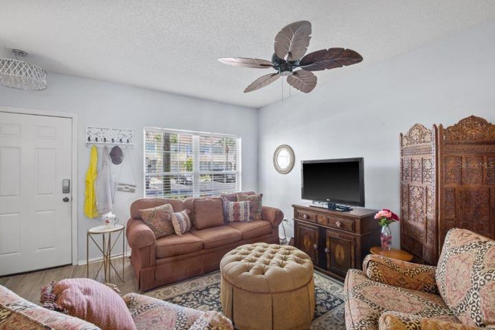 Spacious Living room featuring high ceilings, and wood look tile flooring.