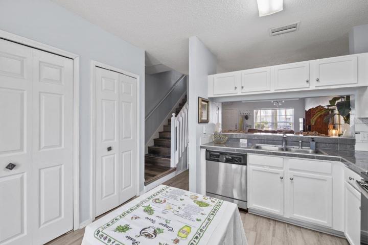 Open Kitchen featuring renovated tile countertops, wood look tile flooring, stainless steel appliances, and direct access to the back lanai