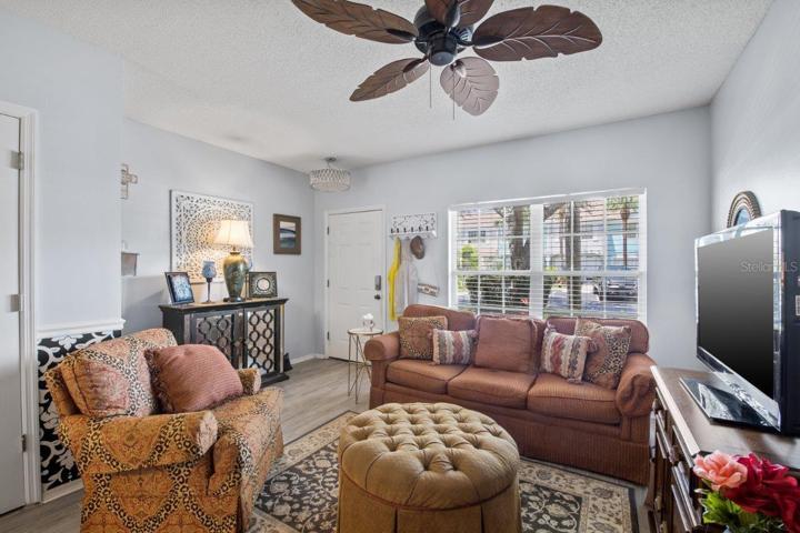 Spacious Living room featuring high ceilings, and wood look tile flooring.