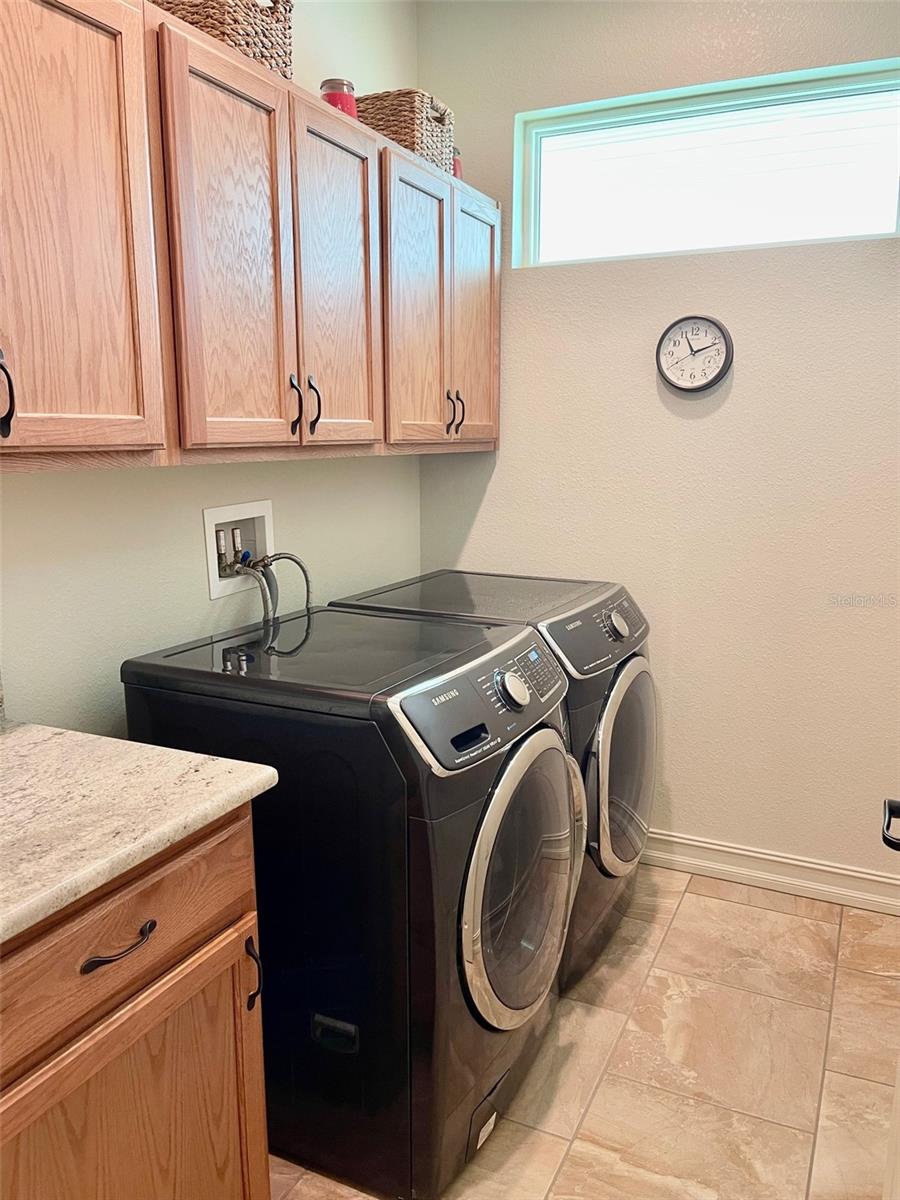LAUNDRY ROOM, PLENTY OF STORAGE CABINETRY AND FOLDING AREA, FRONT LOAD WASHER AND DRYER