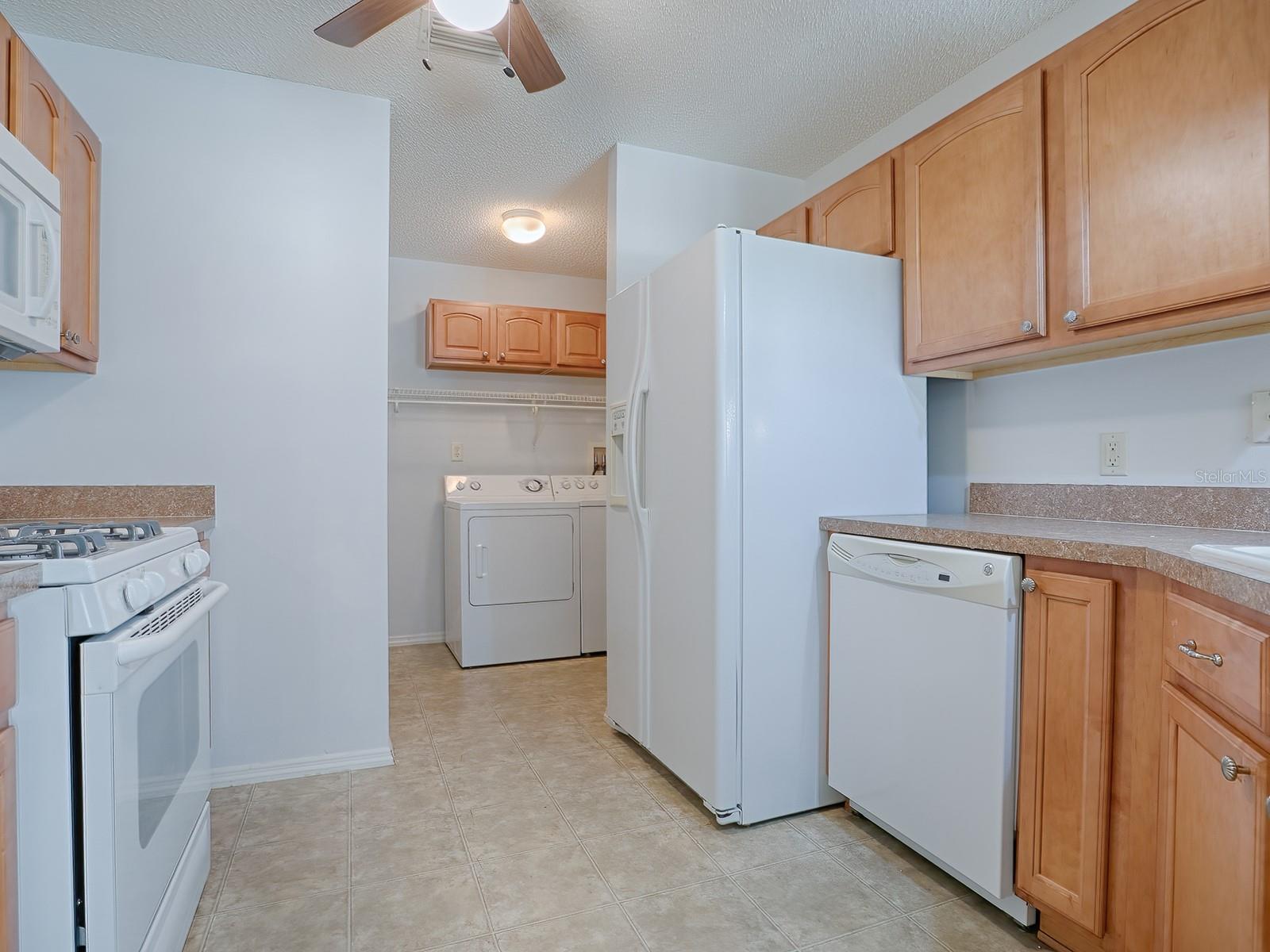 KITCHEN HAS WHITE APPLIANCES AND FEATURES A GAS RANGE