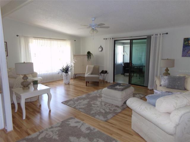Large living room with bay window, light laminate flooring throughout living area
