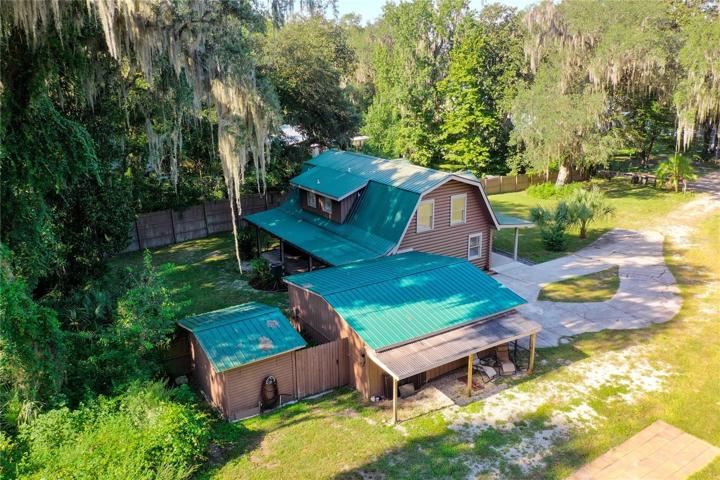 The side of the 2 car garage is covered... use it for a shady afternoon or fence it in for a chicken coop.  The choice is yours!  *** Picture also shows a portion of the RV pad that has full hookup with 50 amp service.***