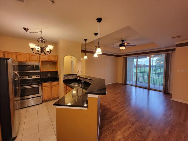 Kitchen open to living area. Sliding doors lead to covered & screened porch with extended golf course views.