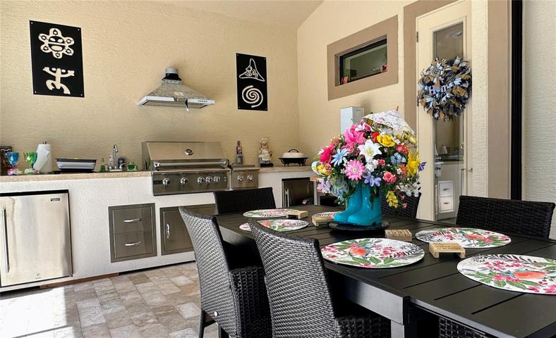 Nestled under the comforting embrace of the covered lanai, this expansive space invites you to savor delectable meals in an enchanting al fresco setting. The grandeur of the summer kitchen seamlessly extends to accommodate a generous dining area, where every meal becomes a feast for the senses.