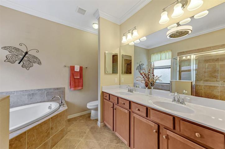 En Suite Master Bath with Double sinks, cultured marble counter tops, custom ceiling fan.
