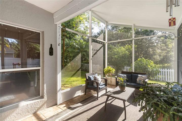 High ceilings continue in this inviting covered, screened-in patio