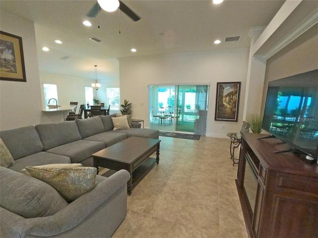 Spacious living room with comfortable wrap around sofa. View lanai and private back plus dining and kitchen. Great entertaining layout with it's open floor plan.Easy care tile throughout