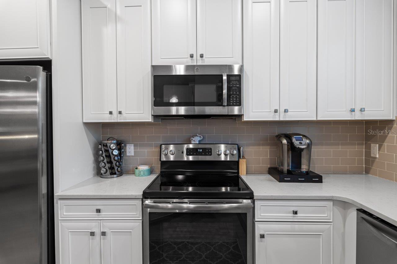Gourmet Kitchen features stainless steel appliances, quartz counters, and 42" cabinetry