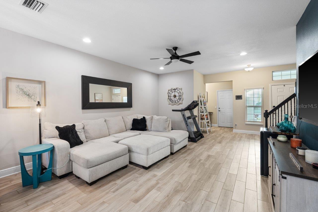 Great Room featuring wood look tile flooring, impact windows, and 10' ceilings.