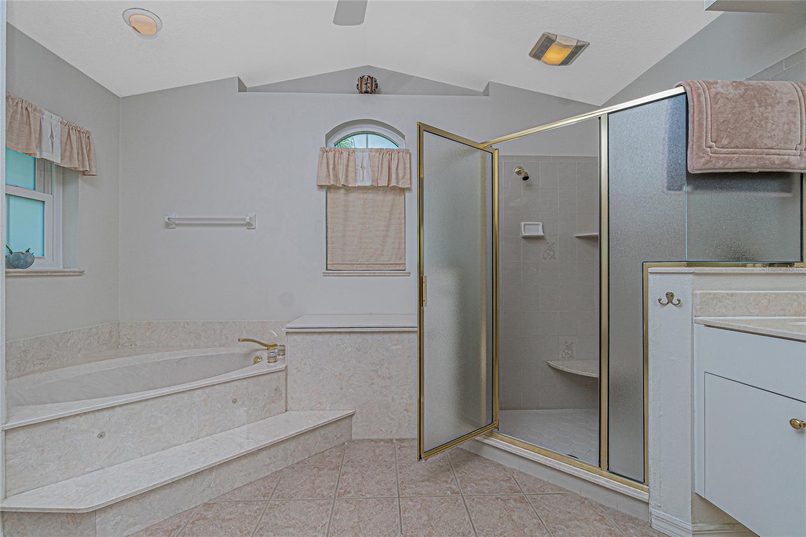 The master bath shower has tiled flooring and glass door.
