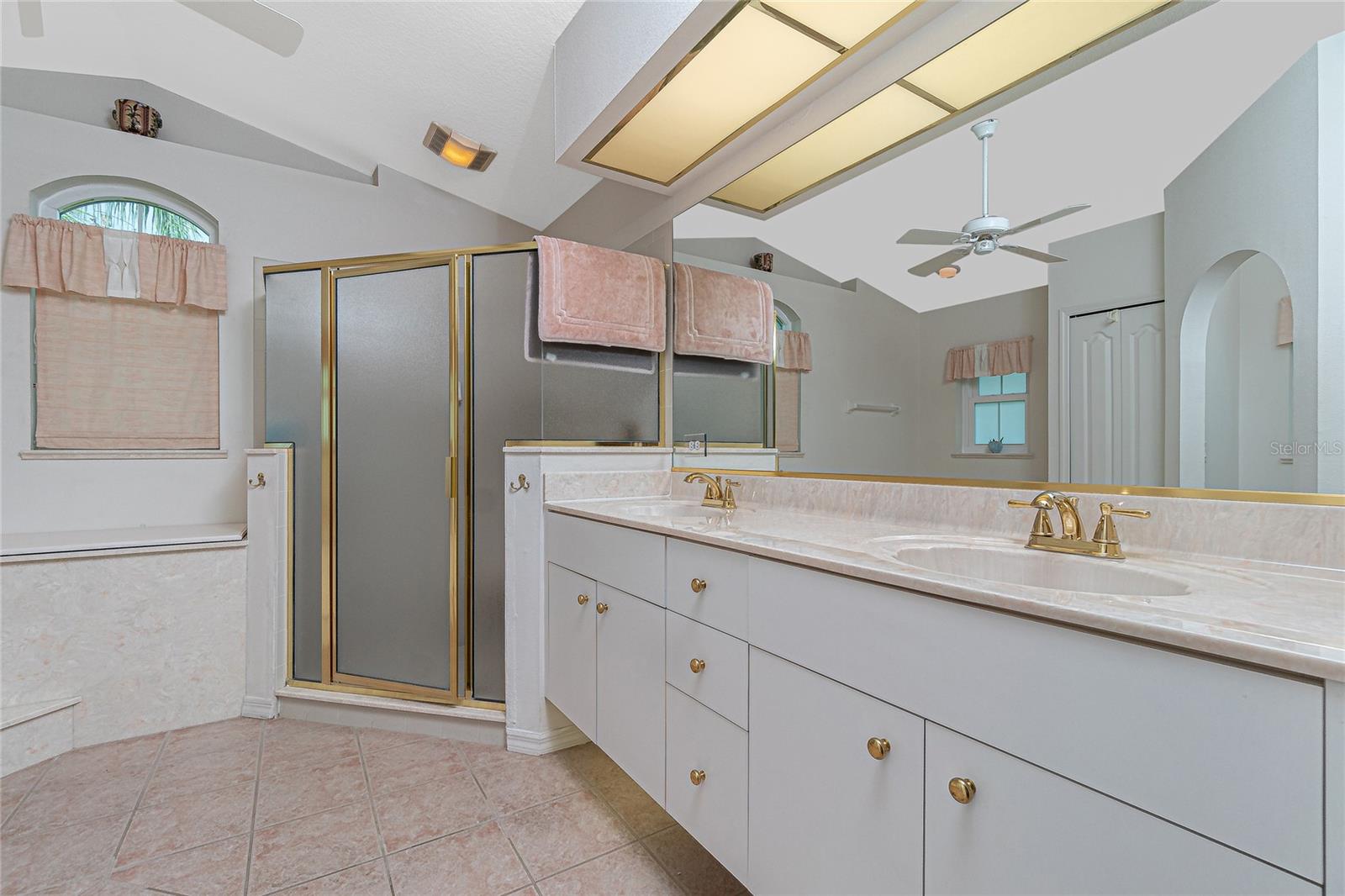 The master bathroom has a step-in shower, vanity w/cultured marble countertop and dual basins.