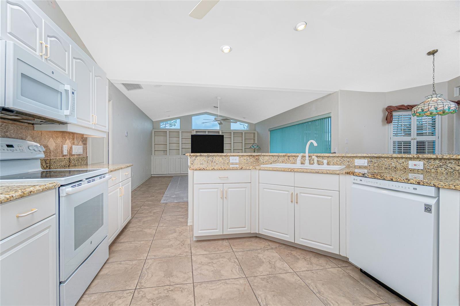 The open kitchen shares space with the family room and looks out to the lanai and pool.