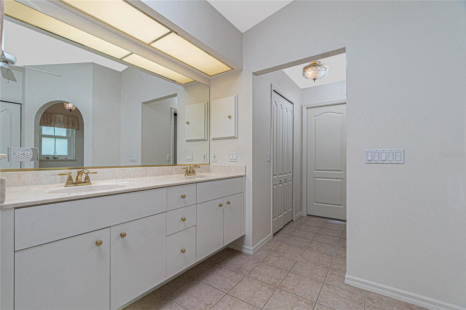The master bathroom has under-vanity lighting, tile flooring and two walk-in closets.