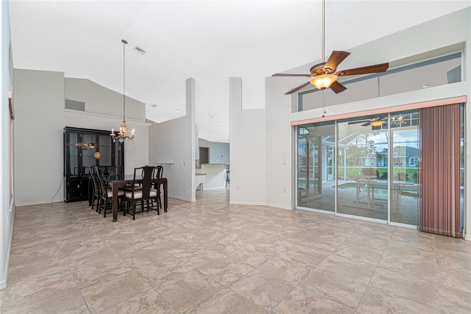 Soaring ceiling over the dining room and living room, which opens to the lanai and pool.